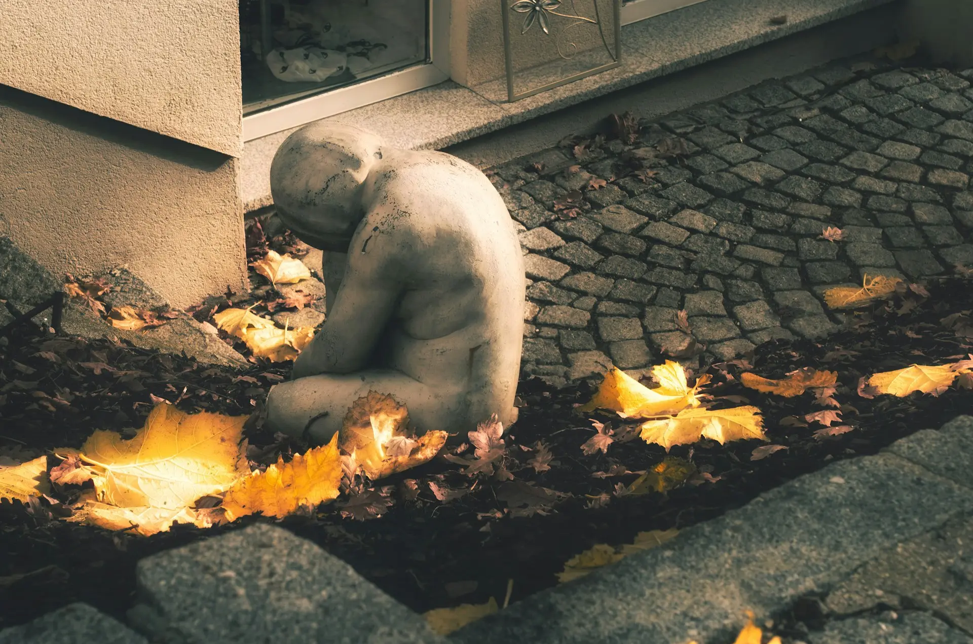 a teddy bear sitting on the ground in front of a building